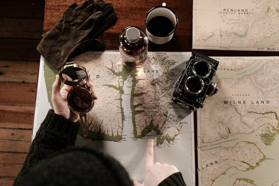 A person reading a map and looking at a globe, symbolizing research about the destination before traveling