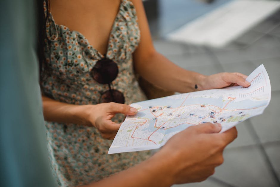 An image of a person looking at a map and a smartphone, representing the use of Google Maps for navigation by solo travelers.